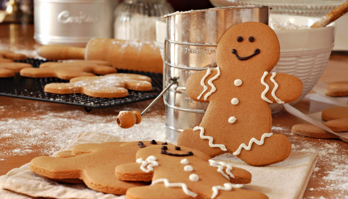 Smiling,Gingerbread,Man,Standing,Next,To,Flour,Sifter,With,Baking
